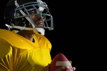 American football player holding a football with both his hands