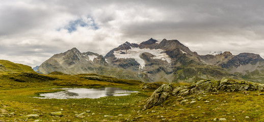 Cloudy mountains and small alpine lake