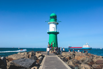 Obraz premium Beautiful summer vibrant view of Warnemunde, Rostock, Germany, popular german seaside resort, with beach, seashore and lighthouse