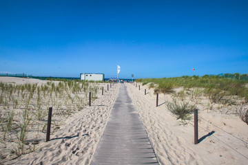 Fototapeta premium Beautiful summer vibrant view of Warnemunde, Rostock, Germany, popular german seaside resort, with beach, seashore and lighthouse