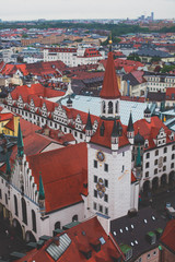 Obraz premium Beautiful super wide-angle sunny aerial view of Munich, Bayern, Bavaria, Germany with skyline and scenery beyond the city, seen from the observation deck of St. Peter Church