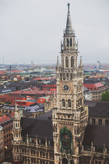 Fototapeta premium Beautiful super wide-angle sunny aerial view of Munich, Bayern, Bavaria, Germany with skyline and scenery beyond the city, seen from the observation deck of St. Peter Church