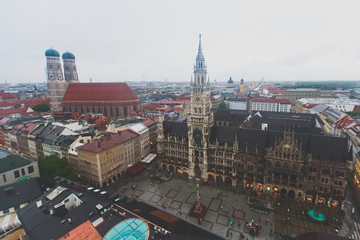 Beautiful super wide-angle sunny aerial view of Munich, Bayern, Bavaria, Germany with skyline and scenery beyond the city, seen from the observation deck of St. Peter Church