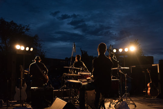 Backlit shot of a small rock band in concert