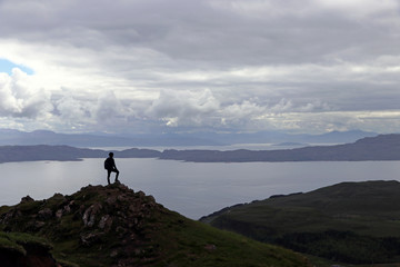 Fototapeta na wymiar Ein Mann steht auf einem Berg hoch über dem Meer