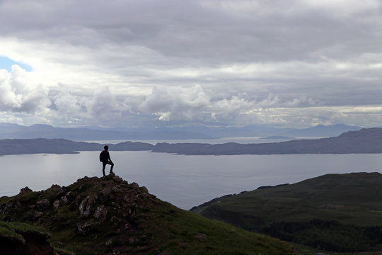 Ein Mann steht auf einem Berg hoch über dem Meer