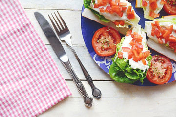 Natural organic salad served on a blue plate on a white wooden table. To view and empty copy space for Editor's text.