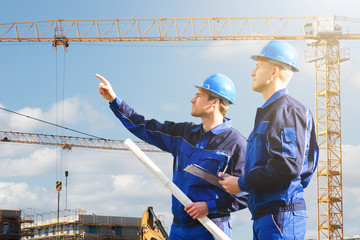 Architect Showing Something To Colleague While Holding Blueprint