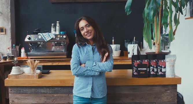RL DOLLY Portrait of young adult female entrepreneur standing in her modern coffee roastrery, looking and smiling into camera. 4K UHD 60 FPS