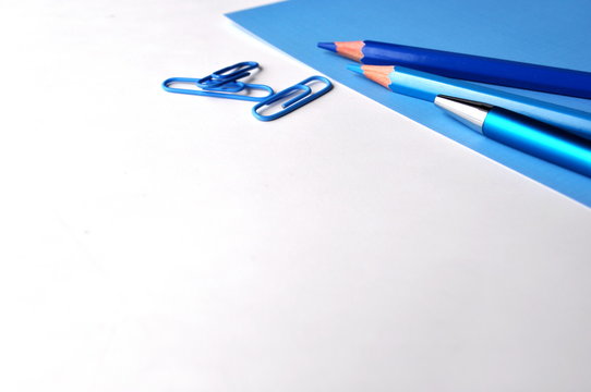 Blue pencils and a pen on white and blue with copy space