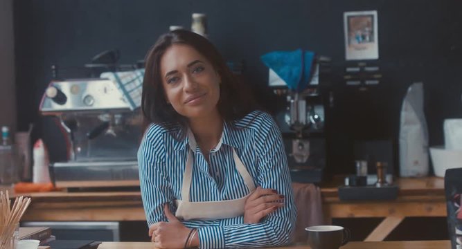 RL DOLLY Portrait of young adult female entrepreneur standing in her modern coffee roastrery, looking and smiling into camera. 4K UHD 60 FPS