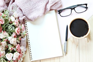 Business, weekend, holiday or good morning concept : Flat lay or top view of scarf, open blank notebook paper, coffee cup and eyeglasses on wooden background