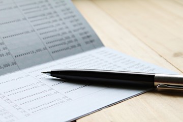 Business, finance, saving money or investment concept : Saving account book or financial statement on desk table