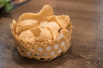 Close up of Fish crackers in the bamboo basket on the Asian restaurant.