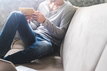 Casual young man using tablet on sofa at home.