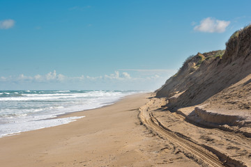 Dirt road winding through sand dunes at the beach