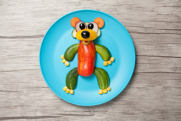 Funny vegetable bear made on plate and table
