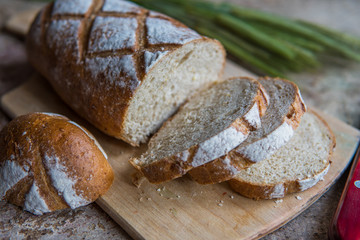 Bread slice on a wooden board. Wheat fresh loaf