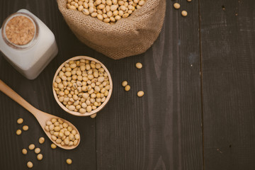 Bottle of soy milk and soybean on wooden table