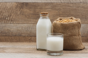 Obraz na płótnie Canvas Bottle of soy milk and soybean on wooden table