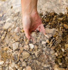Small stones in the hand on the pond