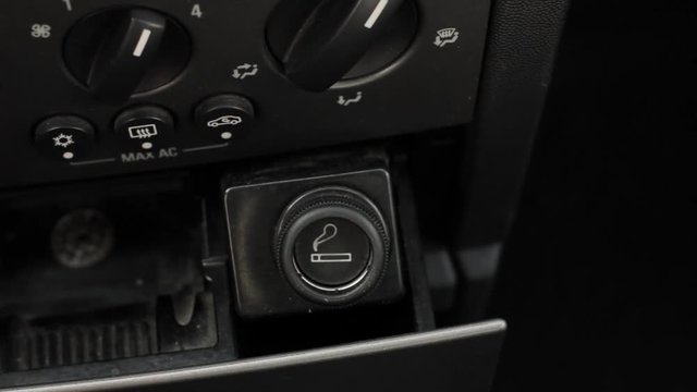 Man hand pressing the car cigarette lighter