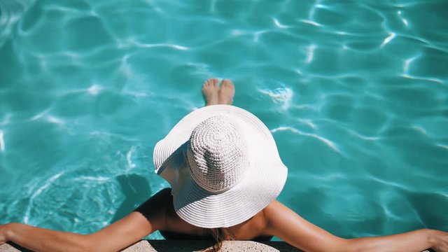 Woman with wide brimmed hat at the pool