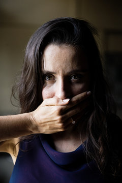 Woman with hand covered over her mouth