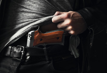 Hand showing a pistol undercover