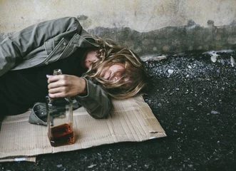 Peel and stick wall murals Bar Homeless woman lay down on the ground holding alcohol