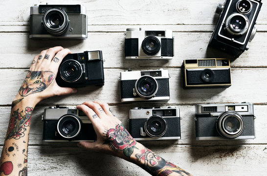 Hands with tattoo holding a camera