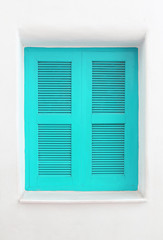 Blue wooden window on white cement wall.