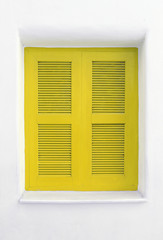 Yellow wooden window on white cement wall.