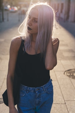 Young cool woman in the city at sunset