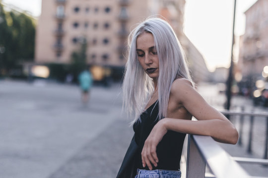 Young cool woman in the city at sunset