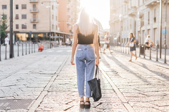 Young cool woman in the city at sunset