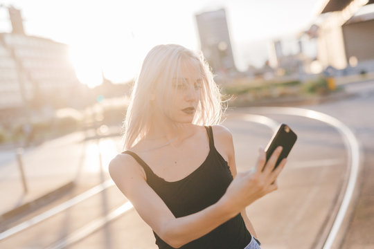 Young cool woman in the city at sunset