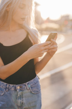 Young cool woman in the city at sunset