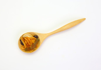 cereal with cashew nut and kiwi in a wooden spoon.