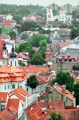 Naklejka premium Fragment of the old town Vilnius panorama with red roofs and towers of churches. Lithuania. Vertical view.
