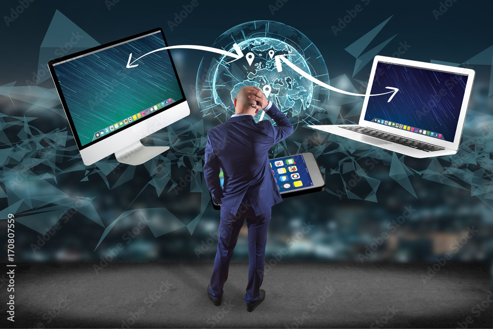 Poster businessman in front of a wall with computer and devices displayed on a futuristic interface with in