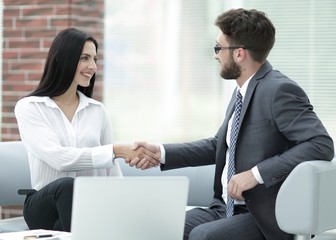 handshake of manager and client sitting in the office lobby.