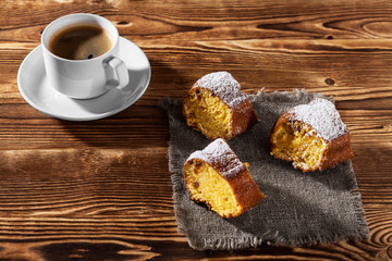 pie on bedding with the cup of coffee on a background a wooden table