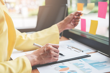 Businesswoman working at his coffee shop and using laptop,  discussing the charts and graphs showing the results of their successful.