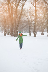 Happy young woman enjoys the snow in nature, park. Winter. concept