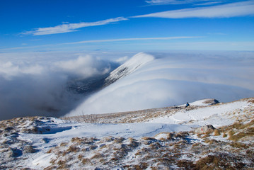 Mountain peak above the clouds. Sunny winter day on mountain above the clouds. Dry mountain in Serbia in winter with highest peak Trem