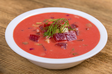 Cold borscht - speciality for hot summer days. Vegetable cold soup with beet, cucumber, potato, radsih and egg . Close up