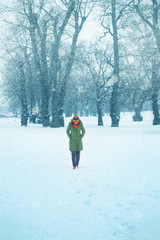 Fototapeta na wymiar Young woman enjoys the walk in a snow in nature. Winter concept