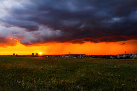 Sunset under field and city