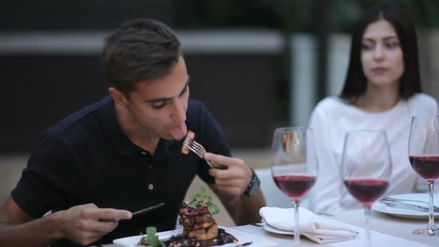 Attractive young man tastes foie gras with sauce